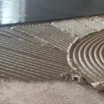 Tegelzetter smeert Coba CTA 120 tegellijm uit op de ondergrond, vocht- en vorstbestendig voor professioneel tegelwerk.