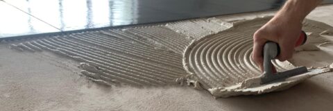 Tegelzetter smeert Coba CTA 120 tegellijm uit op de ondergrond, vocht- en vorstbestendig voor professioneel tegelwerk.